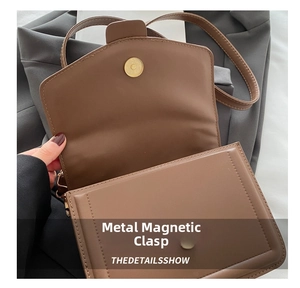 Detail of the high-quality metal magnetic closure on a brown faux leather crossbody bag