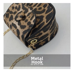Macro view of leopard print mini saddle bag with premium gold metal hardware and chain