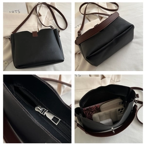 Detail view showing large capacity and zipper closure of the black and brown bucket bag