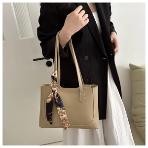 Détail du sac cabas en cuir kaki avec surpiqûres blanches et foulard en soie décoratif