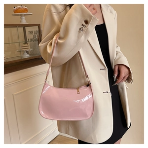 Detail of light pink patent leather baguette bag with glossy finish and gold zipper