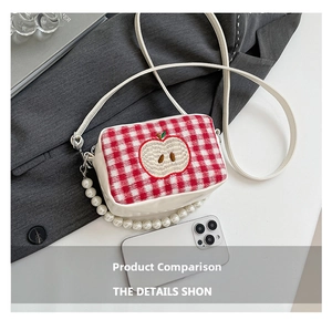 Detail of red checkered knit bag with apple embroidery and large pearl handle strap
