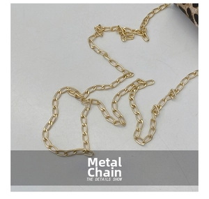 Close-up of golden metal chain hardware on a leopard print mini saddle shoulder bag