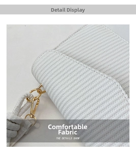 Détail du sac tissé blanc avec texture gaufrée et crochets en métal doré