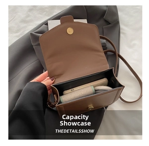 Internal view of brown leather shoulder bag showing capacity for phone and wallet