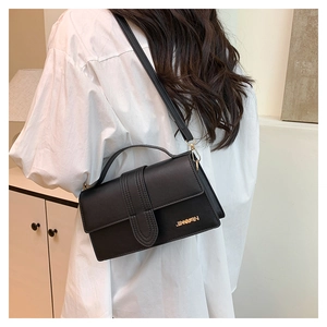 Detail of black leather square bag with gold JINGPIN logo and shoulder strap