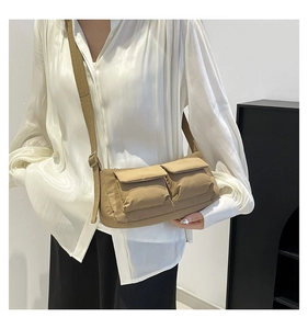 Detail of khaki nylon shoulder bag with dual front pockets and adjustable fabric strap