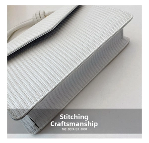 Détails de coutures soignées et de texture tressée sur un sac à bandoulière blanc épuré