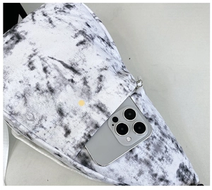 Close-up of the hidden zipper pocket on a marble pattern nylon crossbody sling bag