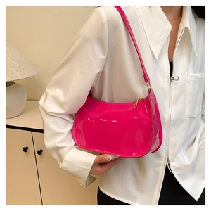 Detail shot of glossy fuchsia patent leather shoulder bag with sleek metal zipper