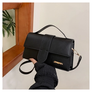 Detail of black leather rectangle crossbody bag with gold JINGPIN logo and top handle