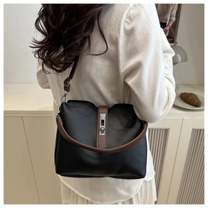 Detail view of the black contrast bucket bag featuring brown straps and silver hardware