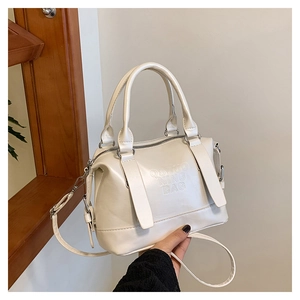 Dettaglio del testo goffrato su questa borsa Boston beige in similpelle morbida