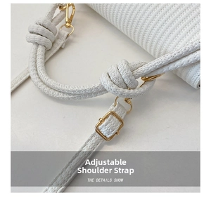 Gros plan du sac tissé blanc montrant la boucle dorée et le détail de la bandoulière