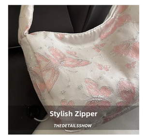 Macro detail of silver jacquard fabric with pink butterfly embroidery and metallic finish