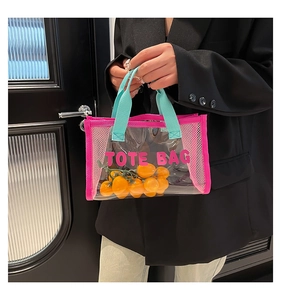 Detail of transparent PVC tote bag with pink mesh sides and green handles