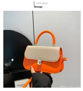 Détail du sac à main orange montrant le rabat tressé et le fermoir tournant en métal doré