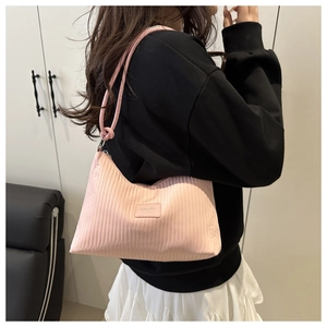 Close-up of pink pleated shoulder bag showing vertical texture and rectangle logo patch