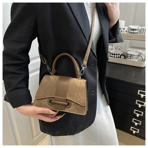 Brown mini crossbody bag in suede and leather mix shown in a daily lifestyle setting