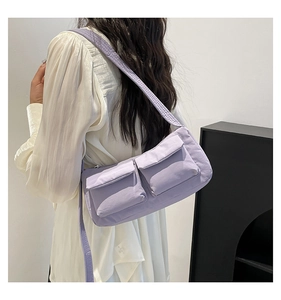 Detailed back view of a light purple nylon crossbody bag with dual utility front pockets