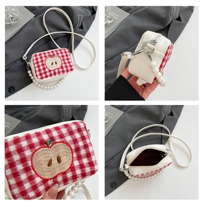 Close-up of red plaid mini square bag with apple embroidery and pearl bead handle