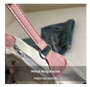 Close-up of pink leather strap and silver metal ring hardware on white pillow bag