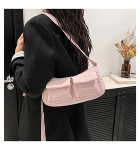 Dettaglio della borsa a tracolla in nylon rosa con due tasche frontali e tracolla regolabile