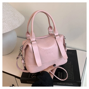 Dettaglio borsa Boston rosa in ecopelle con scritte in rilievo e tracolla regolabile