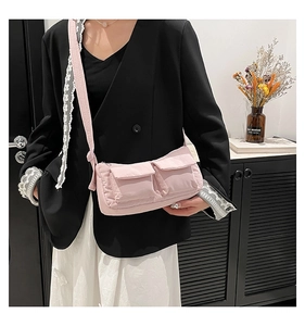 Detail of pink crossbody bag with double front flap pockets and wide shoulder strap