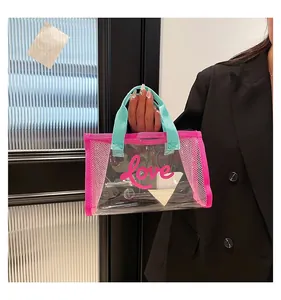 Detail view of pink mesh transparent PVC tote bag with Love print and green handles
