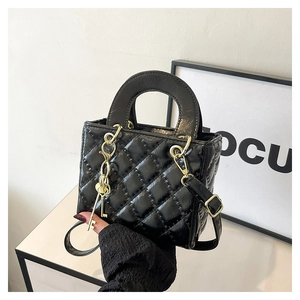 Dettaglio mini borsa trapuntata nera con catena dorata e ciondolo a forma di chiave