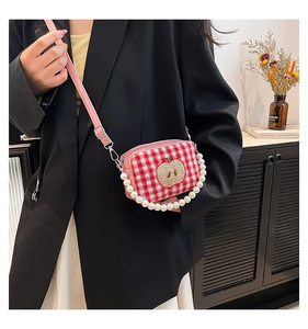 Close-up of red plaid mini bag with apple embroidery and pearl beaded handle detail