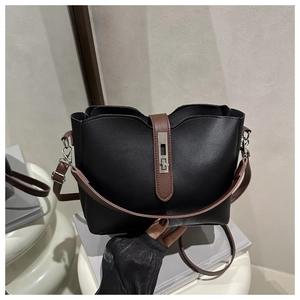 Detail view of black and brown leather bucket bag with silver metal swivel lock