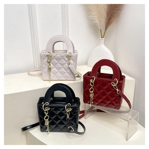 Three quilted crossbody bags in beige, burgundy, and black with metallic key charms