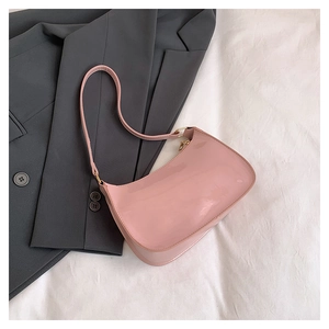 Detail view of pink patent leather hobo shoulder bag with glossy finish and gold buckle