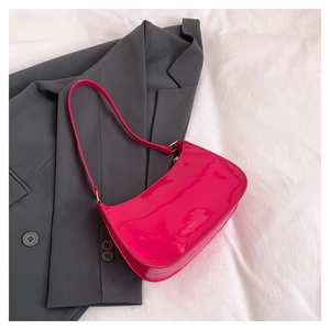 Detail of fuchsia patent leather baguette bag with shiny finish and silver hardware