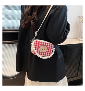 Close-up of red checkered crossbody bag with apple embroidery and pearl chain handle