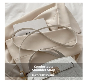 Détails de la texture du cuir litchi blanc et fermoir rotatif doré sur un sac à main