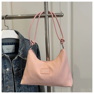 Close-up of pink hobo bag featuring vertical pleated texture and leather logo patch