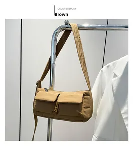 Detail view of brown nylon crossbody bag with dual utility pockets and adjustable strap