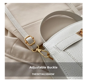 Détail de la texture cuir litchi blanc et boucle métallique dorée ajustable