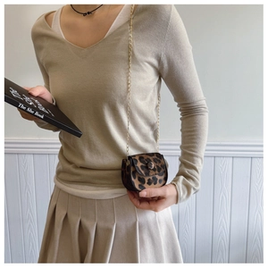Mini leopard print suede saddle bag with gold chain strap shown on model's shoulder