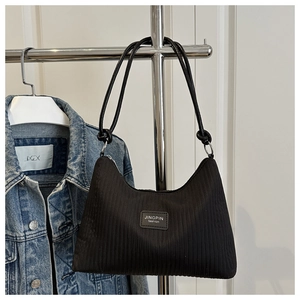 Detail of black vertical stripe texture and JINGPIN leather logo on the shoulder bag