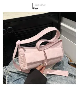 Detailed top view of pink nylon shoulder bag with double pockets and silver zippers
