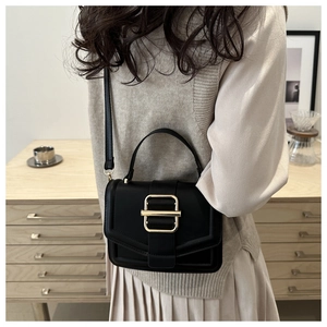Sac à main minimaliste en cuir noir avec fermoir doré dans un cadre de vie moderne