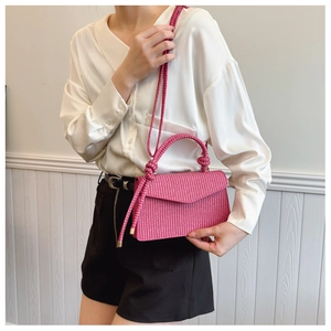 Détail du sac à bandoulière rose en PU tressé avec poignée nouée et rabat élégant