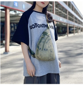 Detail of army green camouflage nylon chest bag with adjustable strap and metal zipper