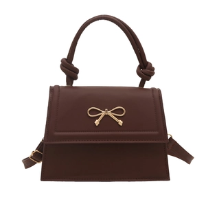 Brown trapezoid leather handbag with gold bow buckle and unique twisted handle design