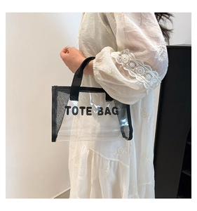 Detail view of transparent PVC tote bag with black mesh panels and Tote Bag printing