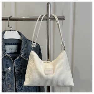 Close-up of white pleated fabric texture and JINGPIN fashion label on small shoulder bag
